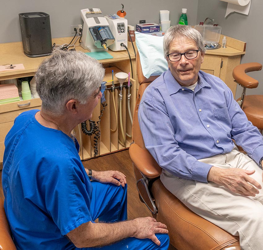 Dr. Andrew J. Sampalis, DDS with a male patient inside the clinic